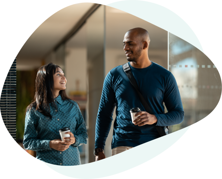Coworkers walking with cups of coffee in hand